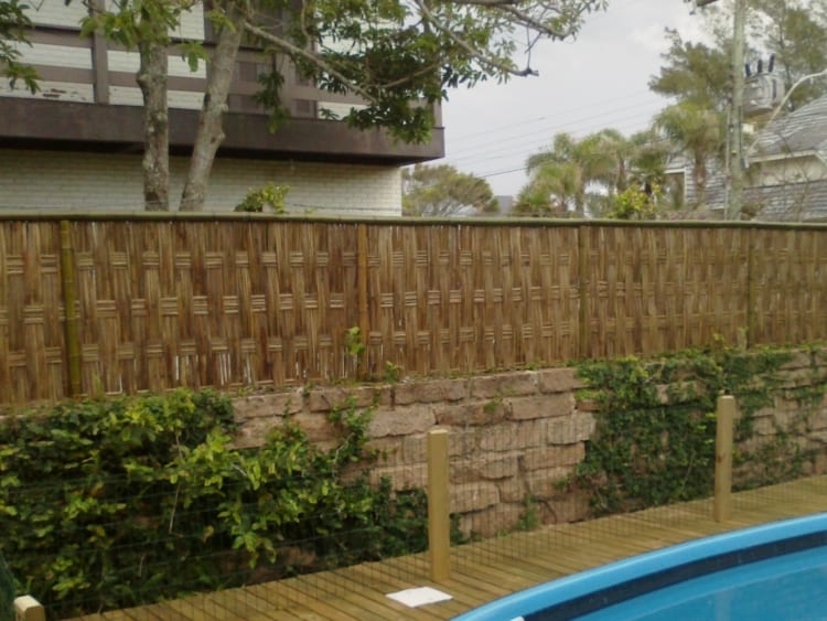 muro de pedra com cerca de bambu trançado